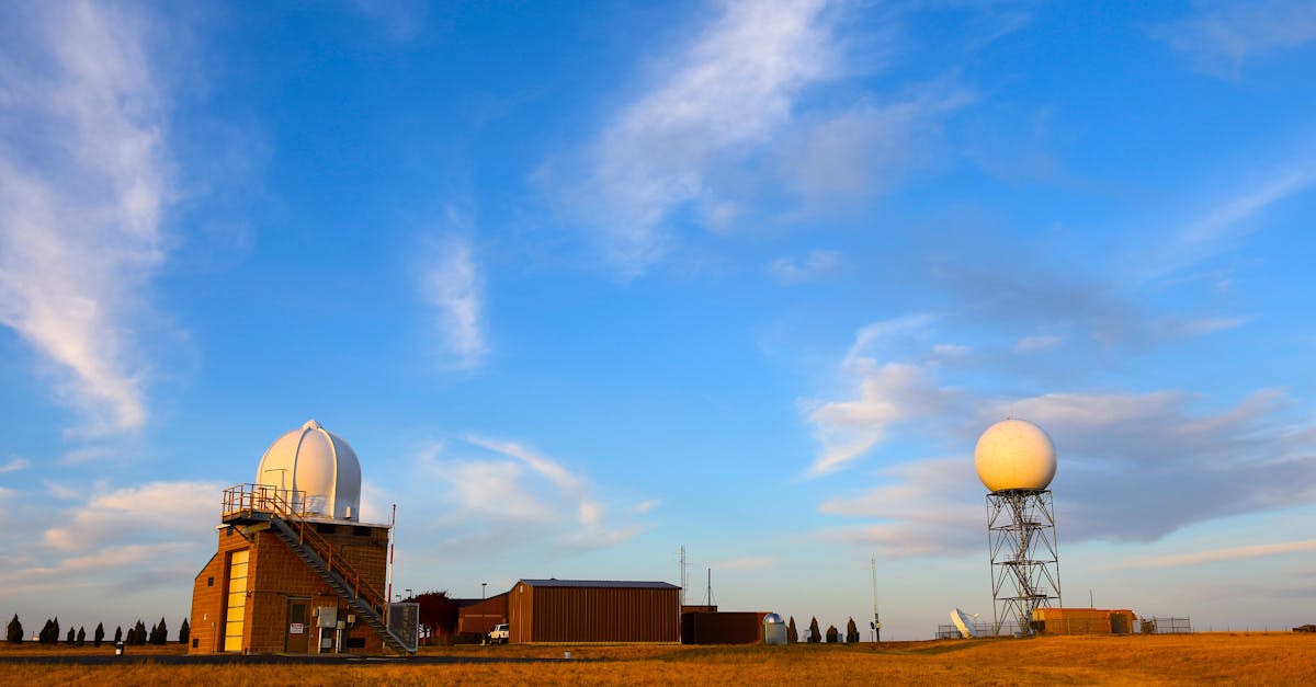 weather radar station set in a field with a clear blue sky and scattered clouds showcasing meteorol