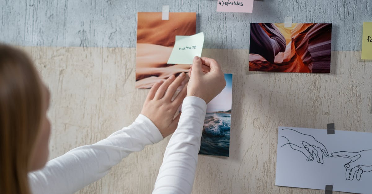 woman arranging photos and notes on a moodboard for a creative project
