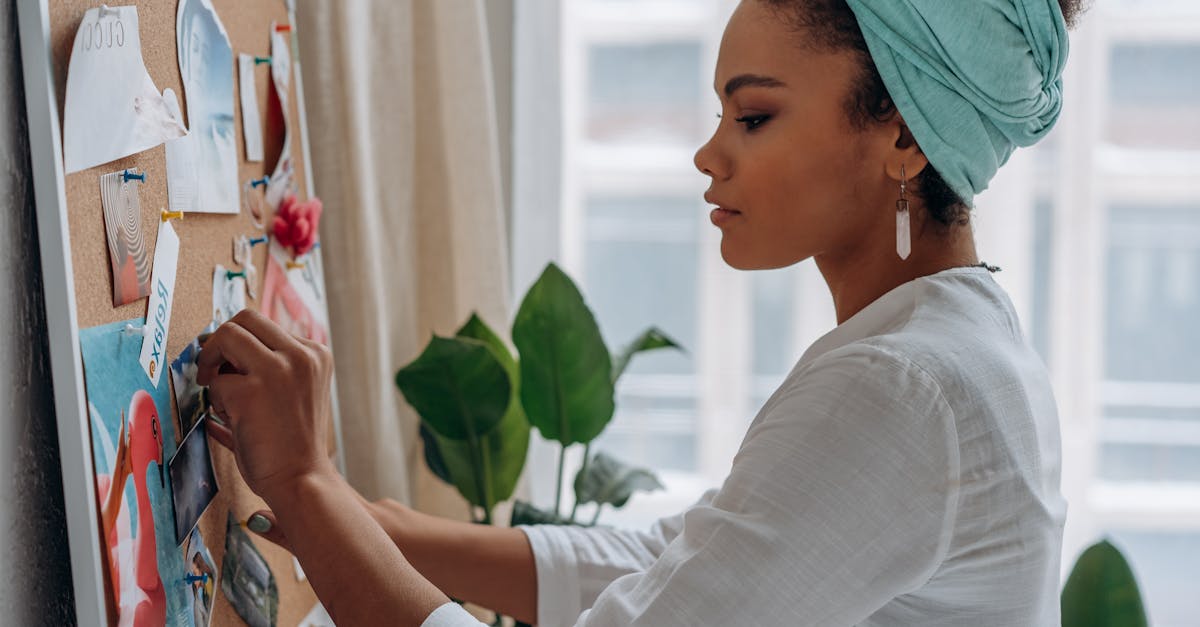 woman creating a vision board with images in a stylish home setting showcasing creativity and focus 2