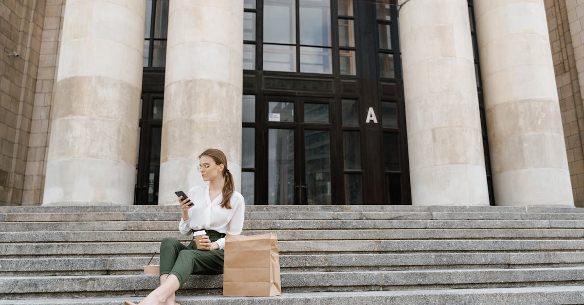 woman sitting on steps with coffee and smartphone casual modern lifestyle moment