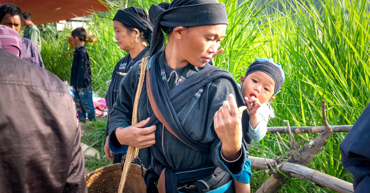 a mother carries her child while engaged in farming activities in a lush rural landscape