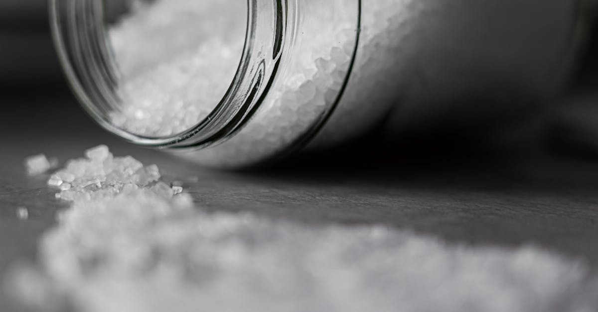 detailed image of rock salt pouring out from a glass jar with a selective focus effect