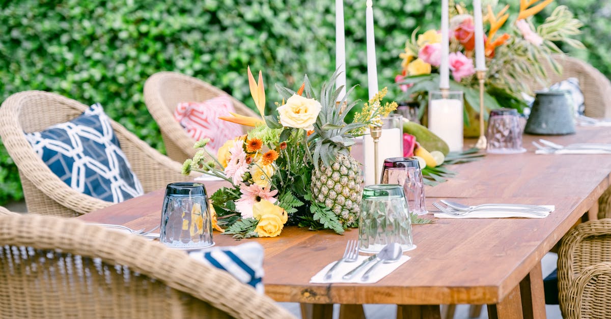 elegant outdoor dining table with tropical floral arrangements and wicker chairs