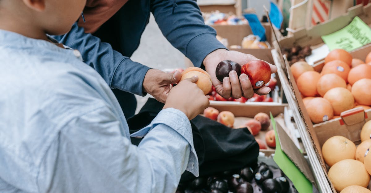 father and son choosing fresh fruits together at a local market stand