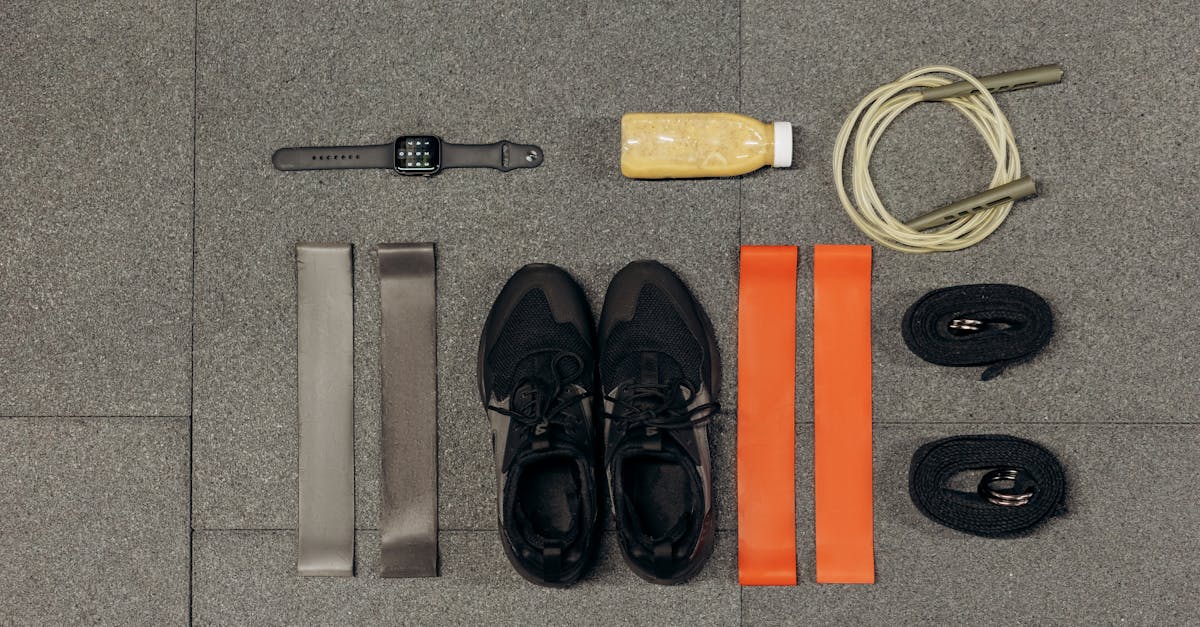 flat lay of workout essentials including sneakers bands watch rope and healthy drink