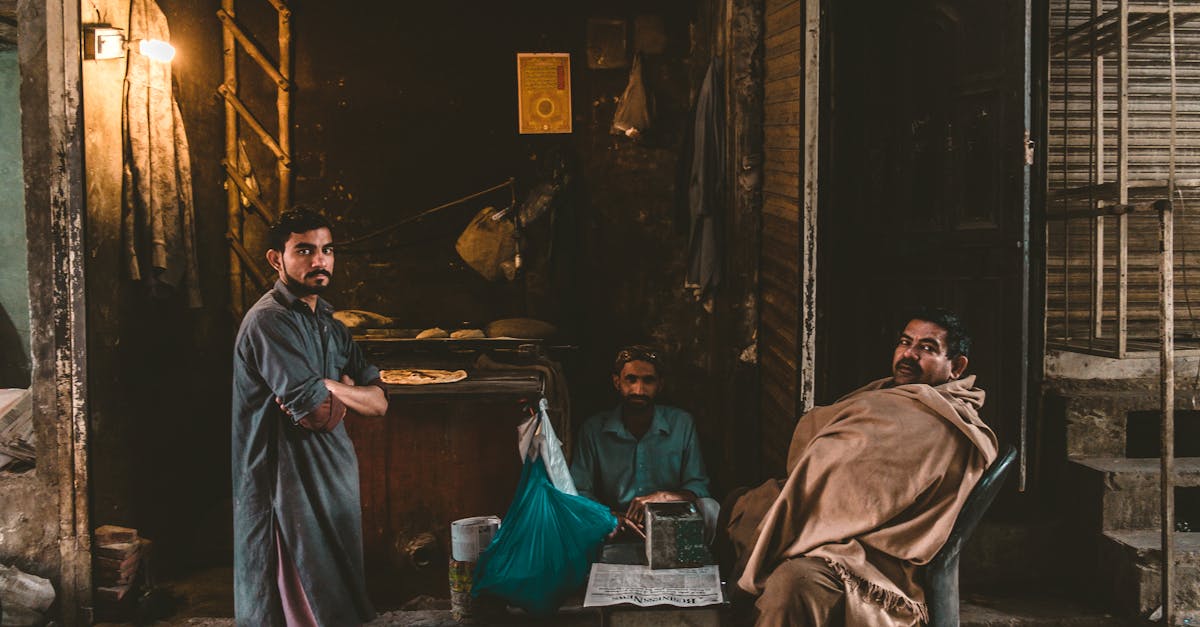 three men in traditional attire in a rustic indoor setting evoking a warm and vintage atmosphere