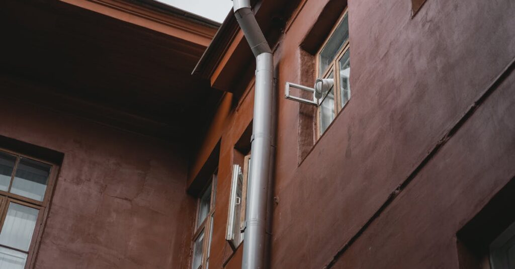 a brown building exterior with pipes and windows photographed from a low angle
