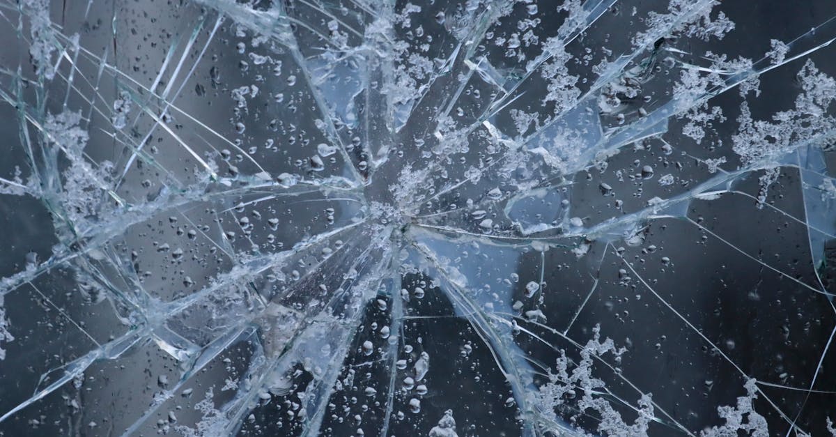 a close up view of shattered glass with frost and water droplets evoking winter in sweden