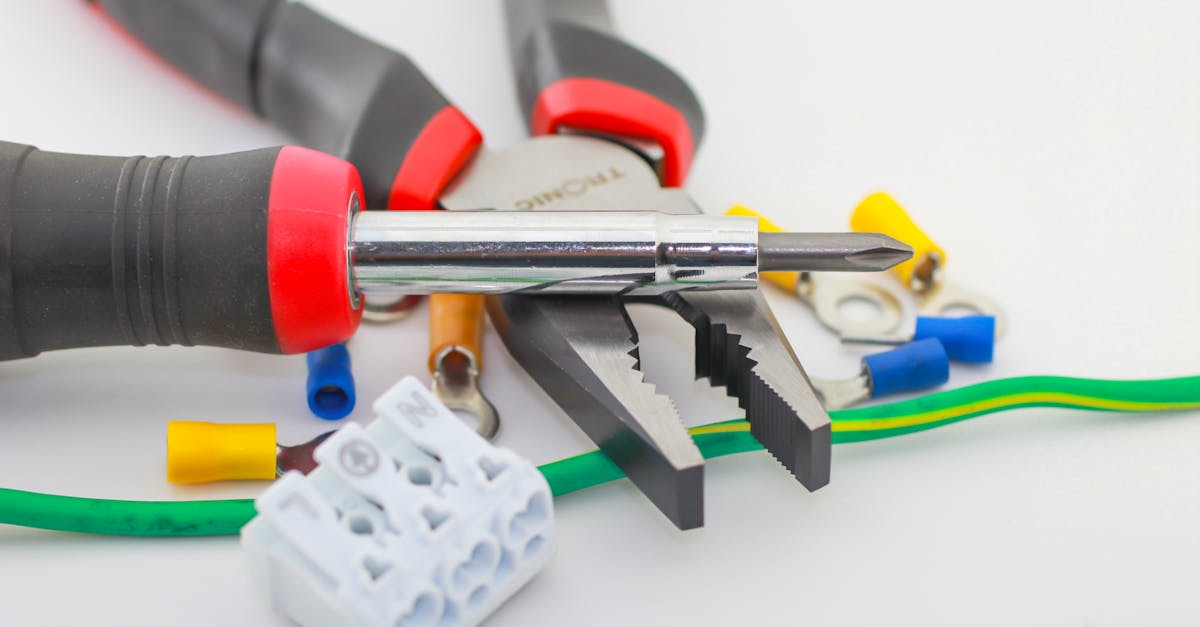 a detailed close up of hand tools including a screwdriver and pliers with various wiring accessories