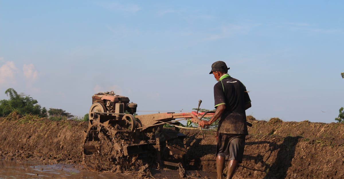 a farmer operates a hand tractor in a muddy paddy field in magetan indonesia