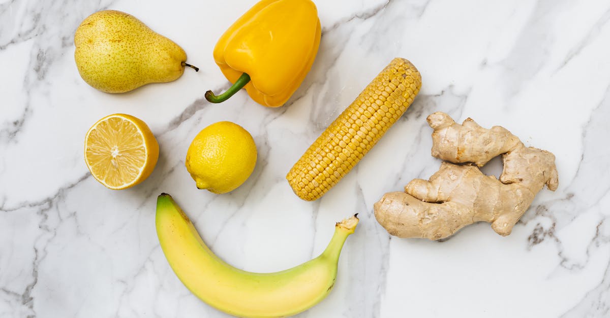 a flat lay of fresh fruits and vegetables on a marble surface showcasing colorful produce