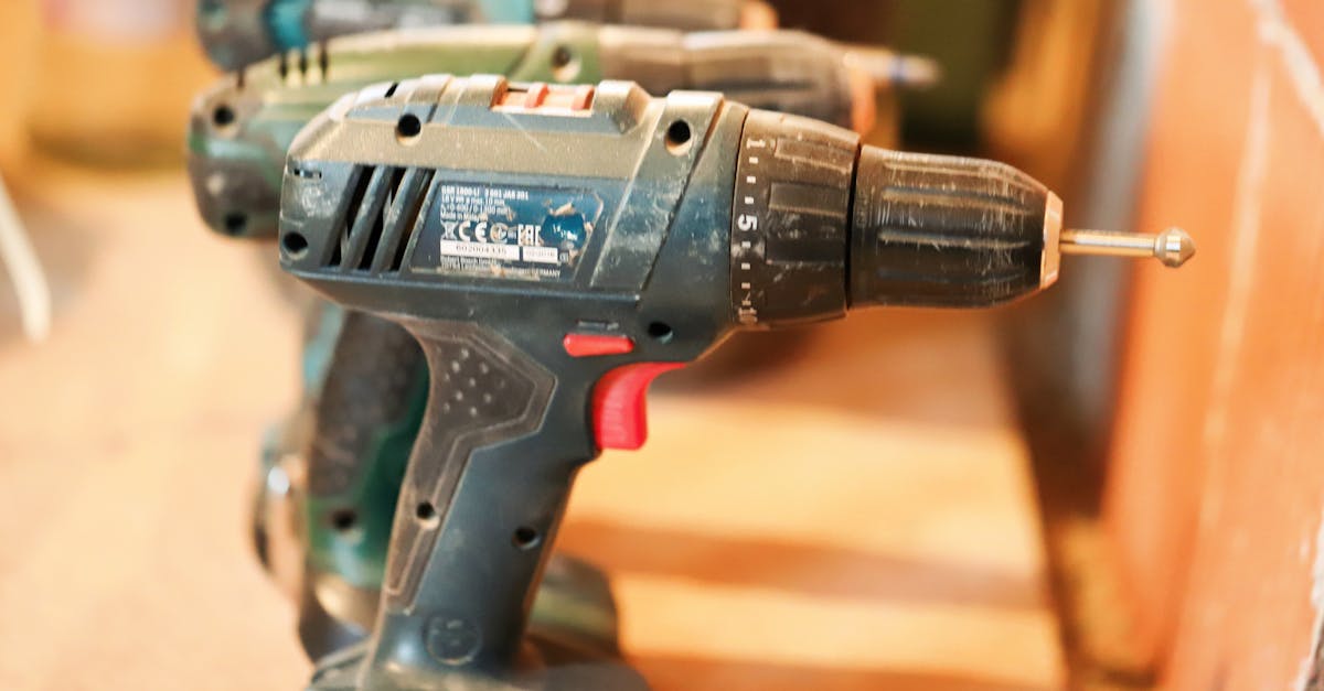 a row of cordless power drills on a wooden workbench ready for use