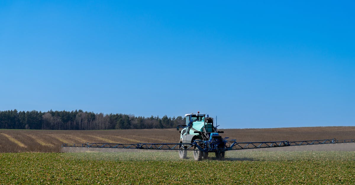 a tractor with spraying equipment fertilizing crops on a sunny day