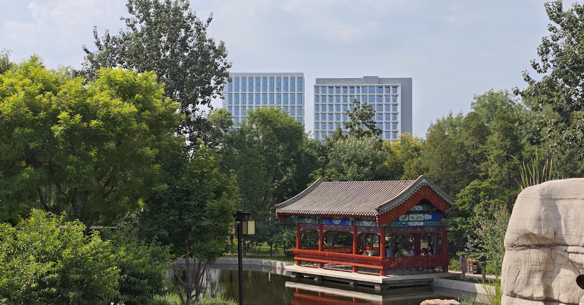 a tranquil scene featuring a traditional chinese pavilion surrounded by lush greenery in an urban pa