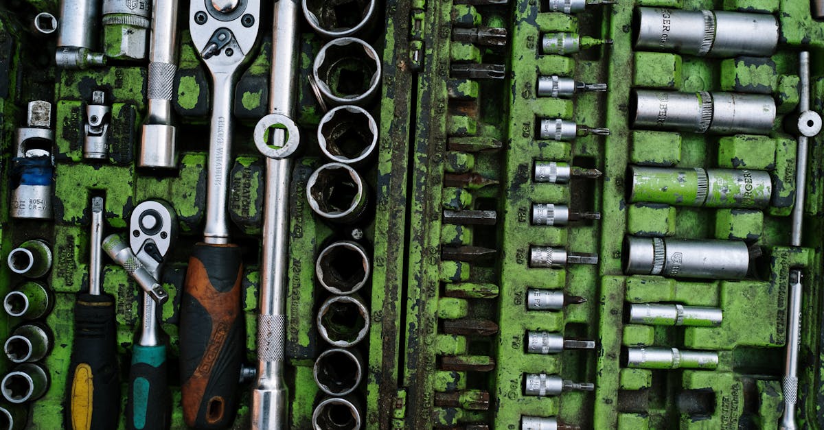 a well organized set of metal tools in a green toolbox with ratchets and screwdrivers