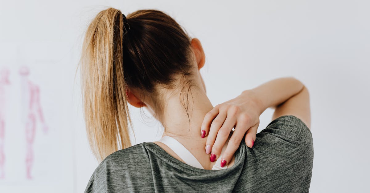a woman in casual clothing holds her neck indicating pain or discomfort