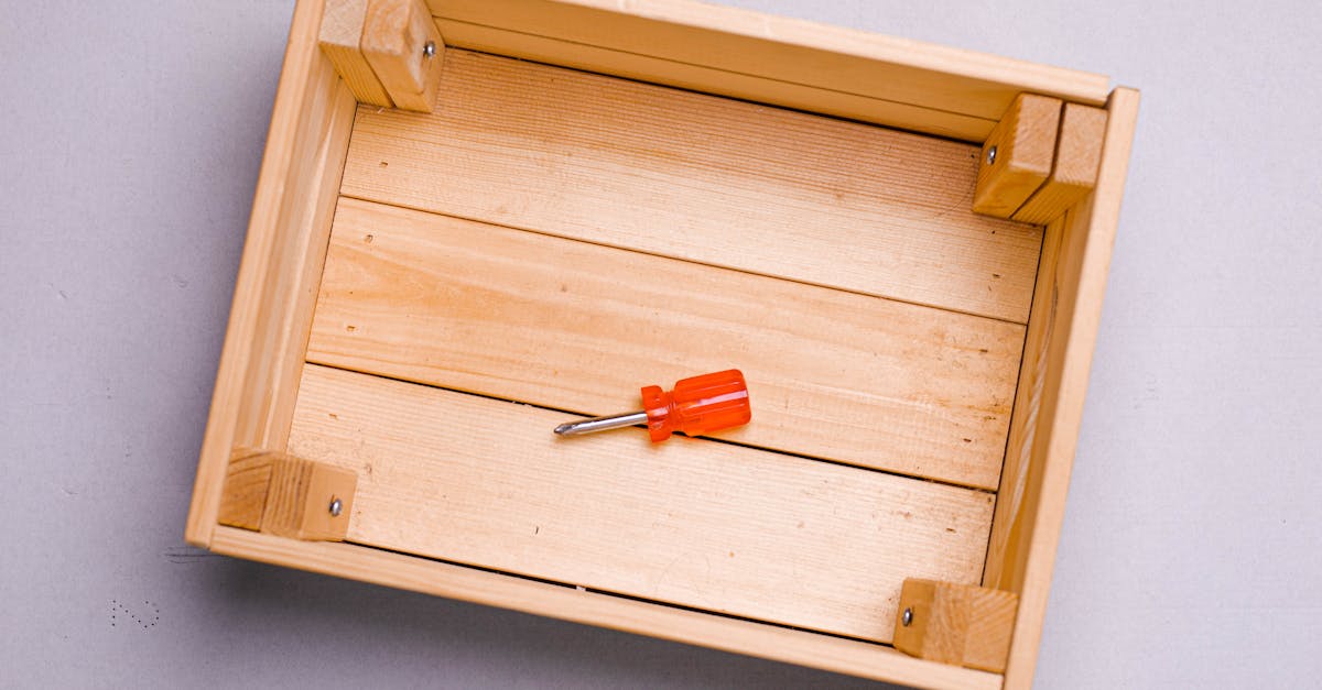 a wooden box displaying a red screwdriver on a grey background