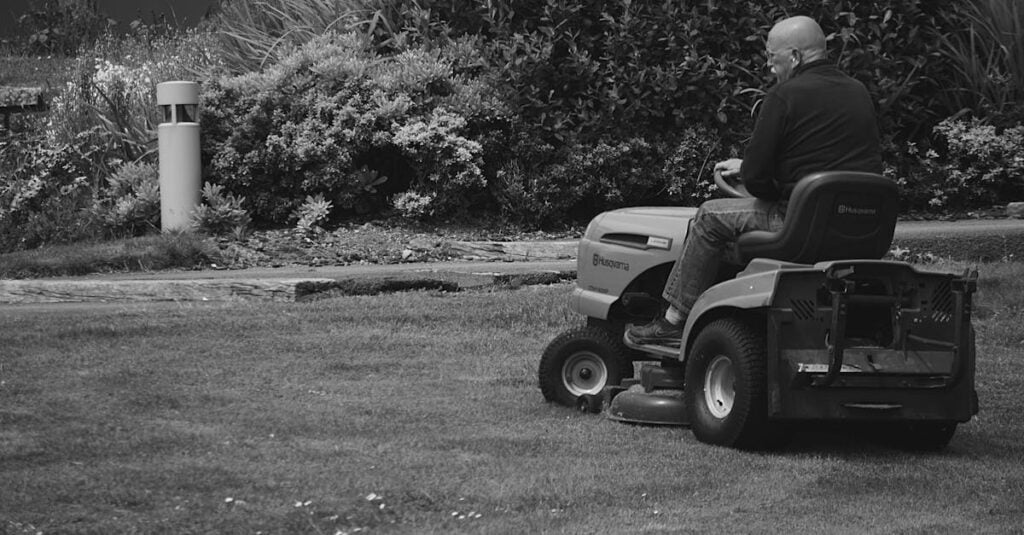 adult mowing grass on a ride on lawn mower in a garden setting 1