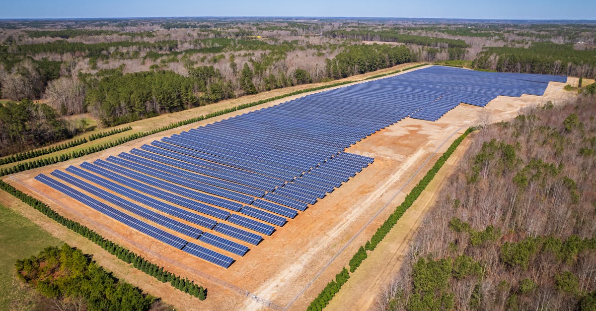 aerial drone shot of a large solar panel farm in a rural area surrounded by forests in north carolin