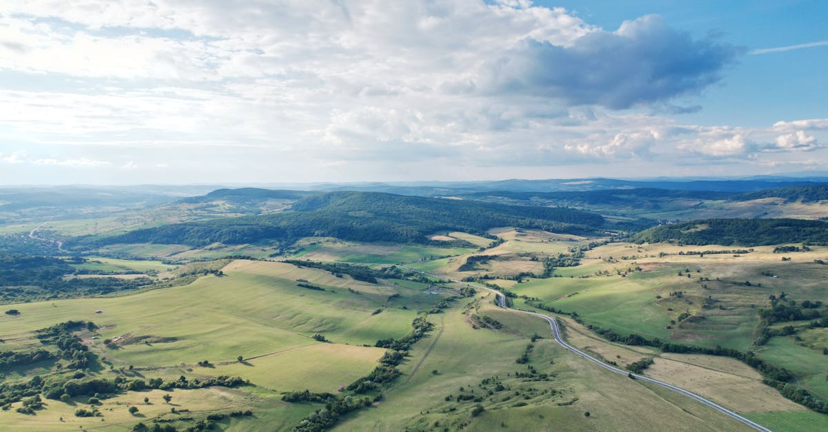 aerial view showcasing the lush sprawling countryside with rolling hills under a blue sky