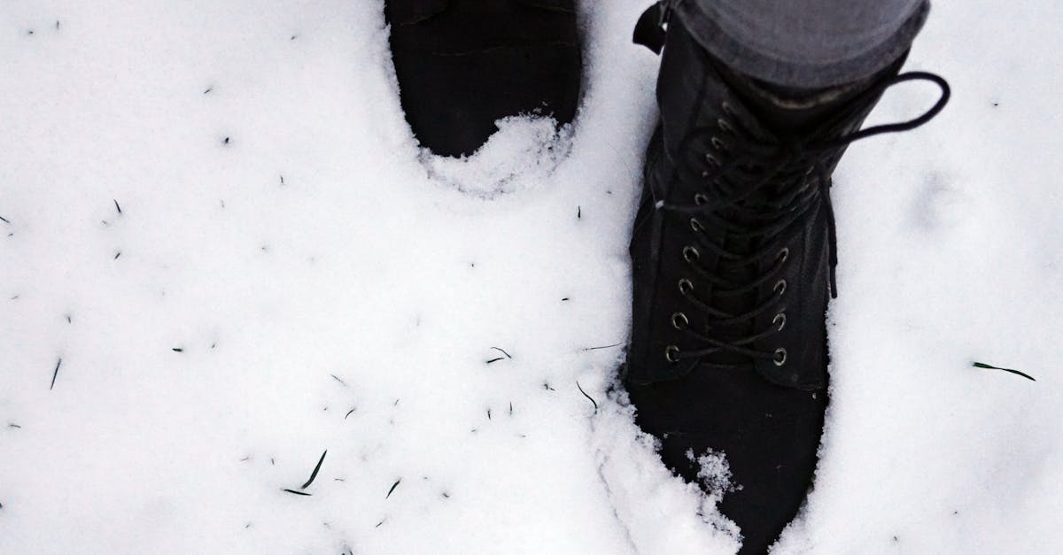 black boots make a footprint in fresh snow capturing a wintery scene outdoors
