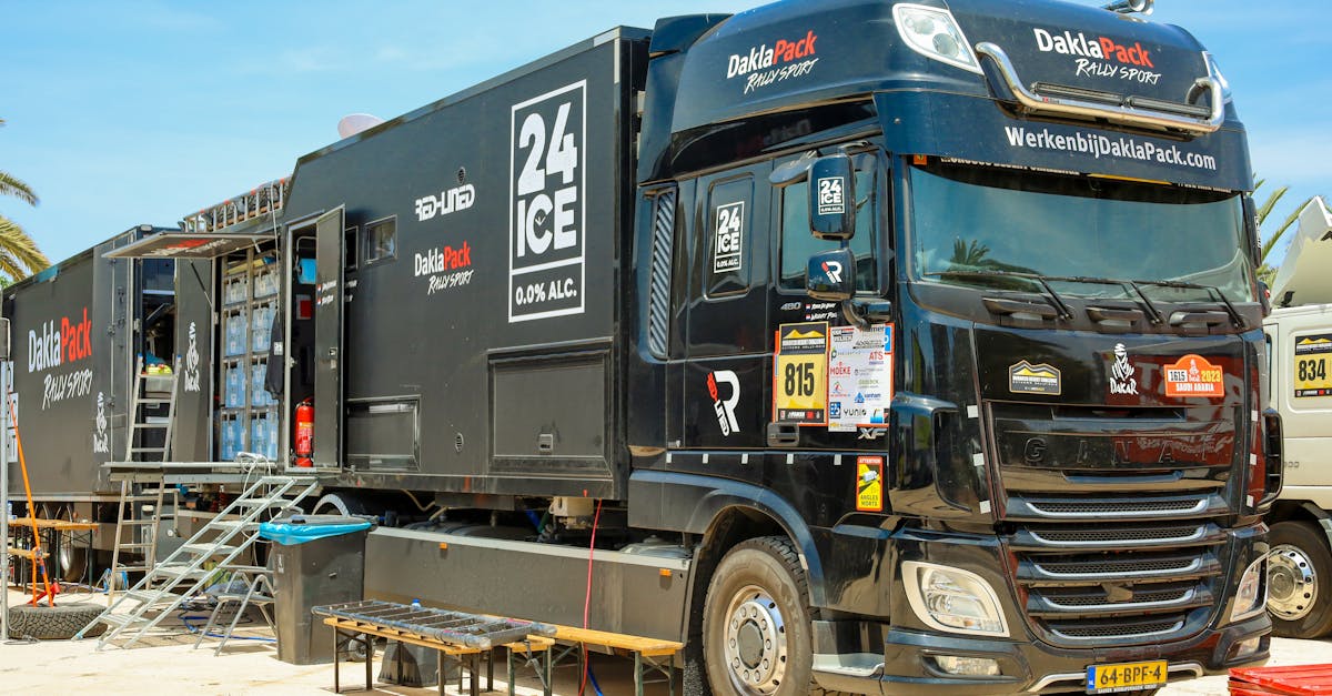black daklapack rally truck with logos and equipment parked outdoors on a sunny day 3