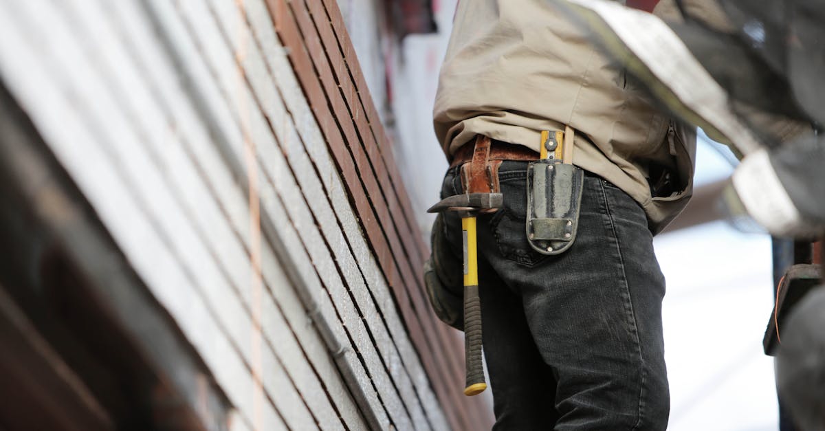 close up of a construction worker with hammer and tools focused on the job