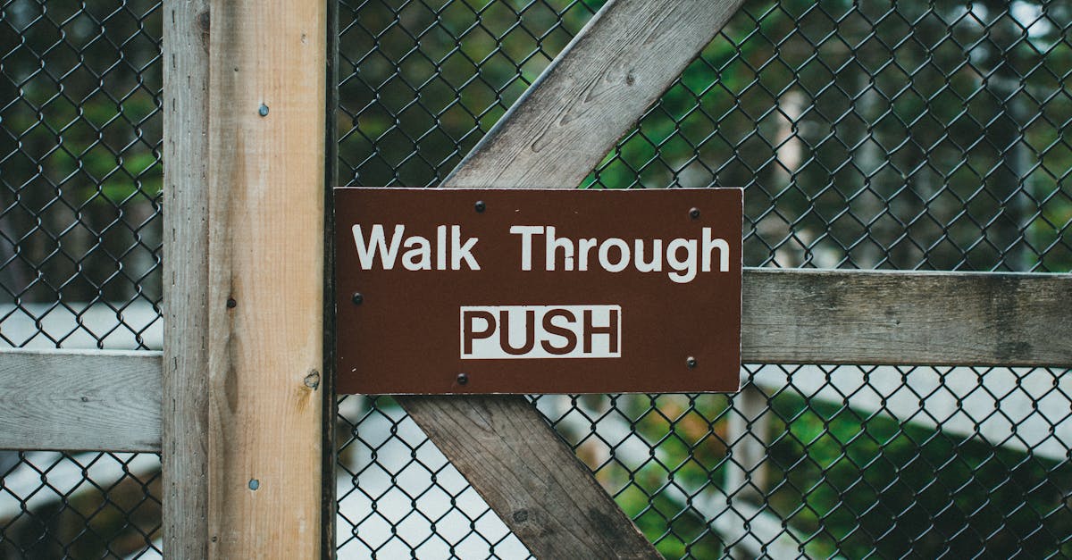 close up of a wooden gate with metal fence and walk through push sign