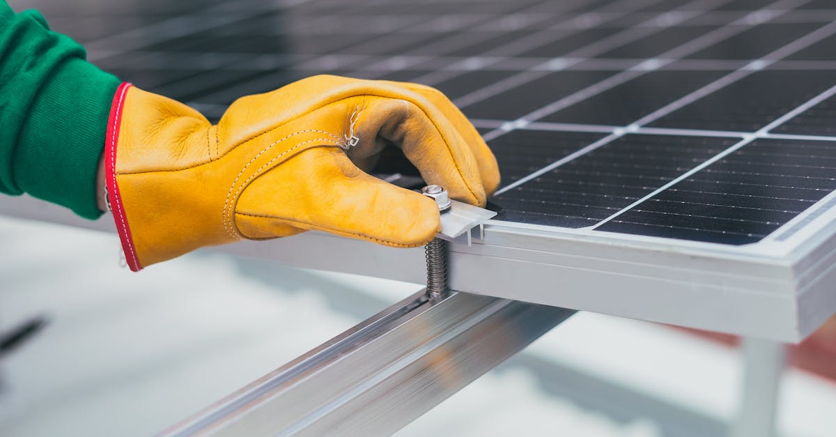 close up of a worker s hand with protective gloves adjusting a bolt on a solar panel