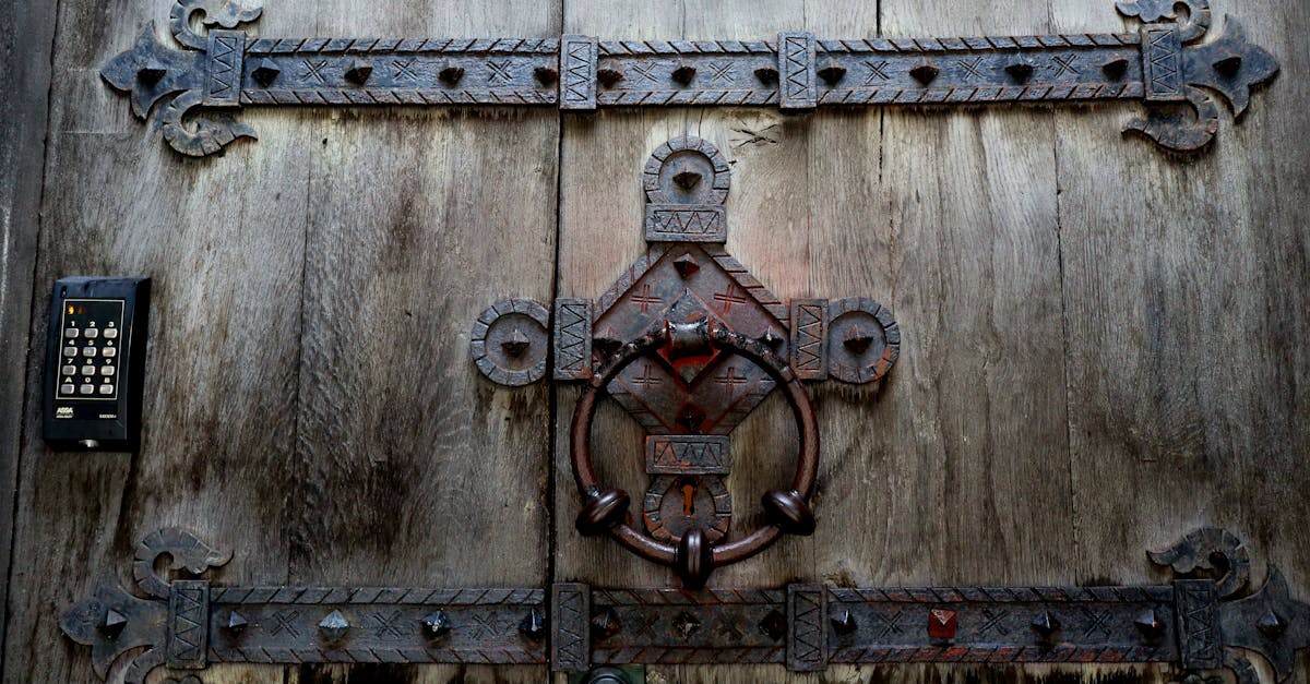 close up of an antique wooden door with intricate metal design and keypad entry
