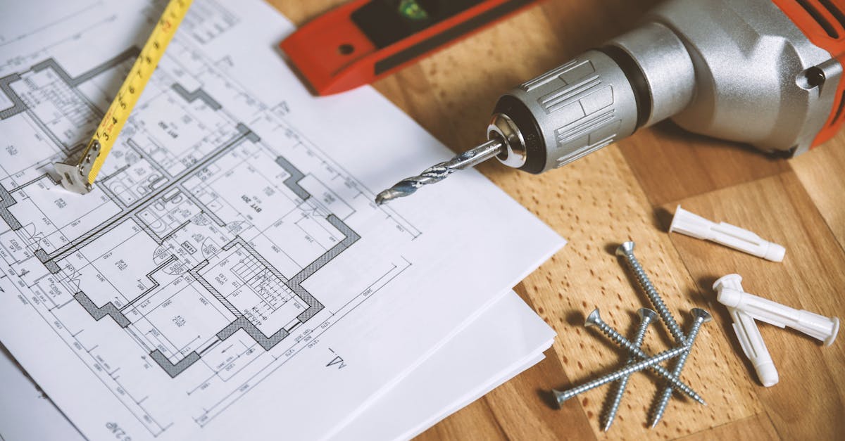 close up of construction blueprint with tools like drill and screws on a wooden table 2