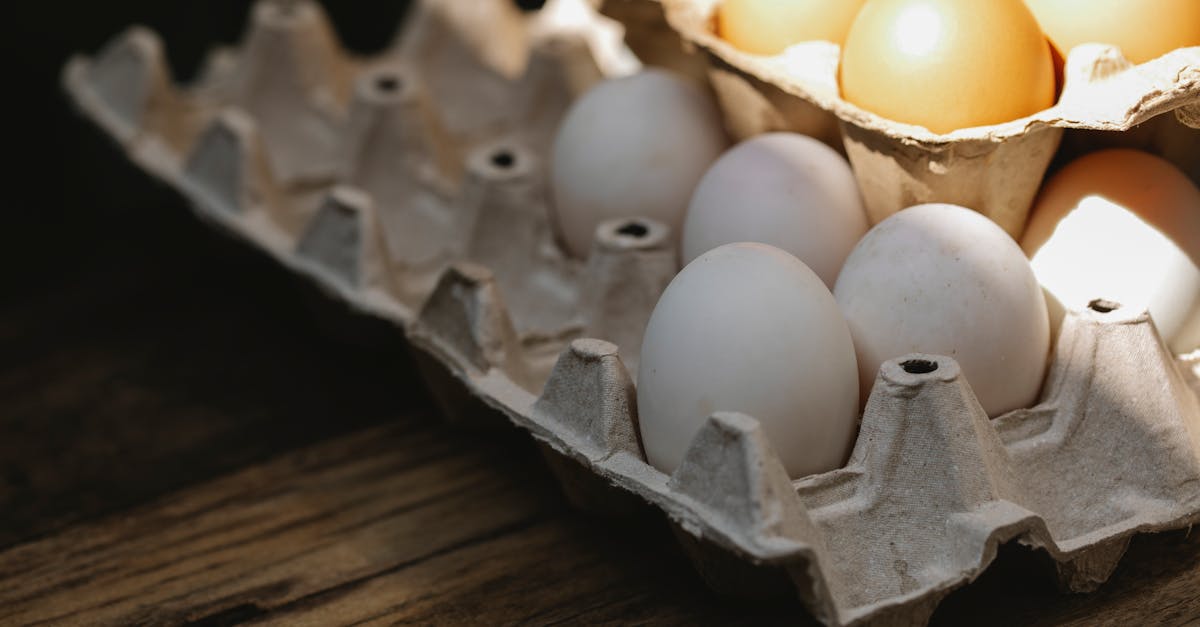 close up of fresh organic eggs in a rustic carton on a wooden table lit by natural sunlight 2
