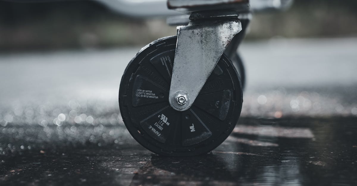 close up photo of a metal caster wheel on a wet surface showcasing industrial design