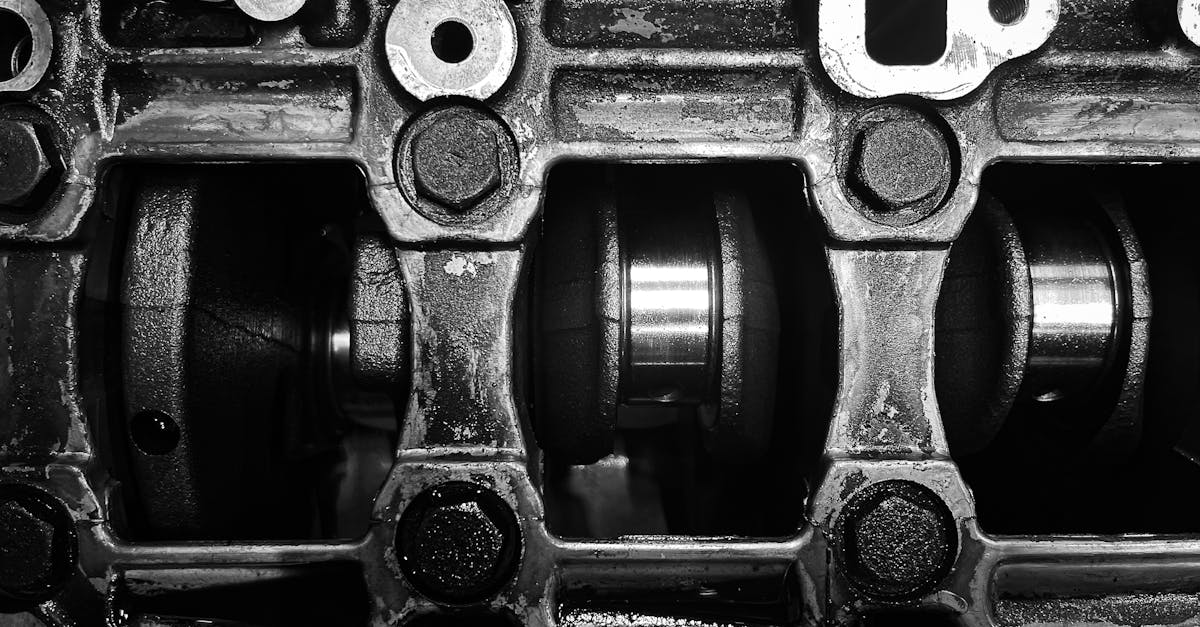 detailed black and white close up of a metal engine crankshaft mechanism