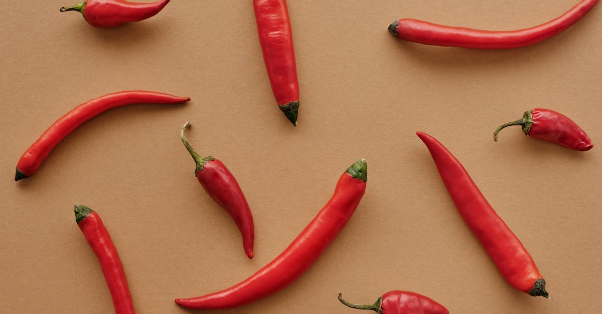 flat lay of red chili peppers arranged on a brown textured background showcasing vibrant color cont