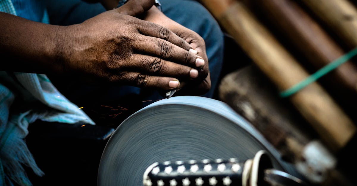 hands sharpening a knife against a rotating grindstone in a market setting