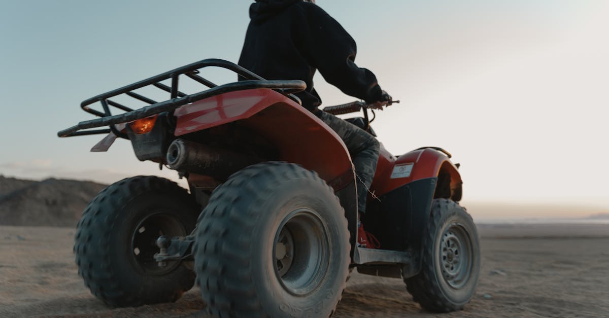 man riding a quad bike in the desert at dawn capturing adventure and thrill