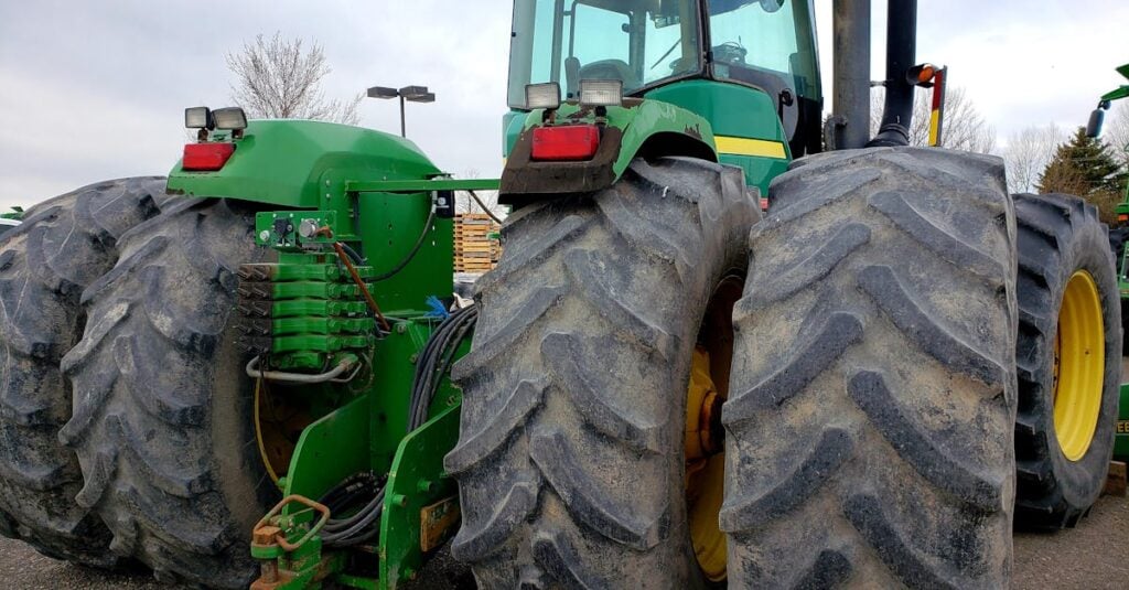 massive green tractor with large tires suited for heavy duty agricultural work