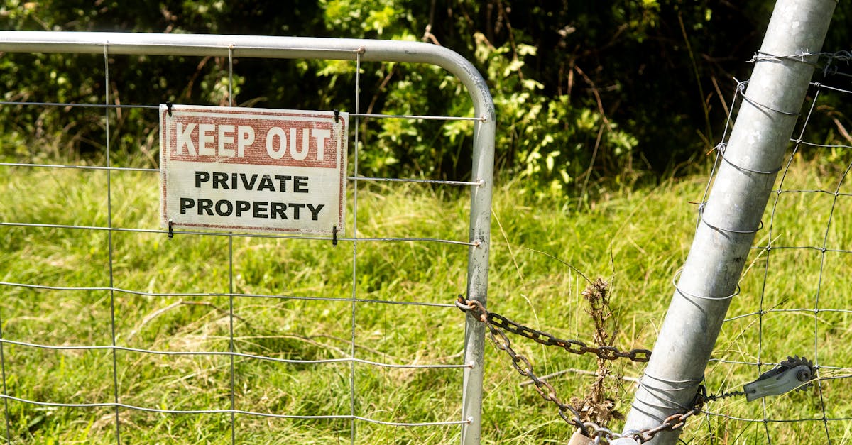 metal fence with keep out private property sign in a grassy outdoor setting 1