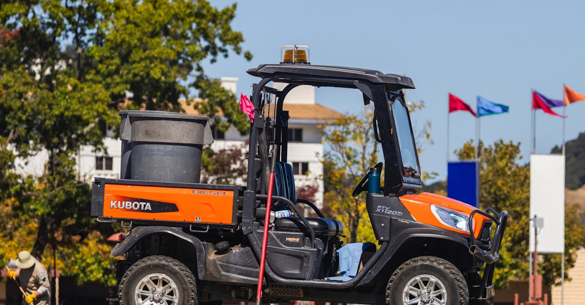 orange kubota rtv on display outdoors with flags in the background