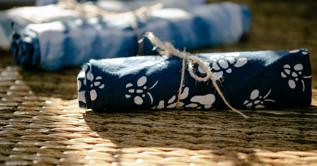 rolls of colorful dyed fabric tied with ropes placed on wicker surface in modern light professional
