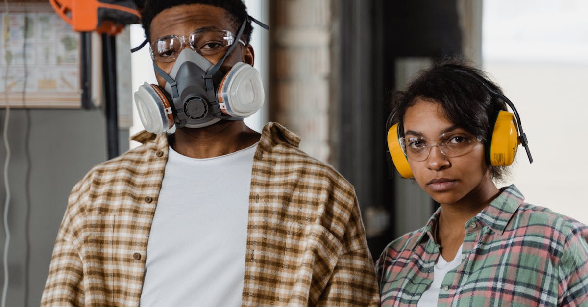 two workers in safety gear stand indoors highlighting protective equipment in an industrial setting