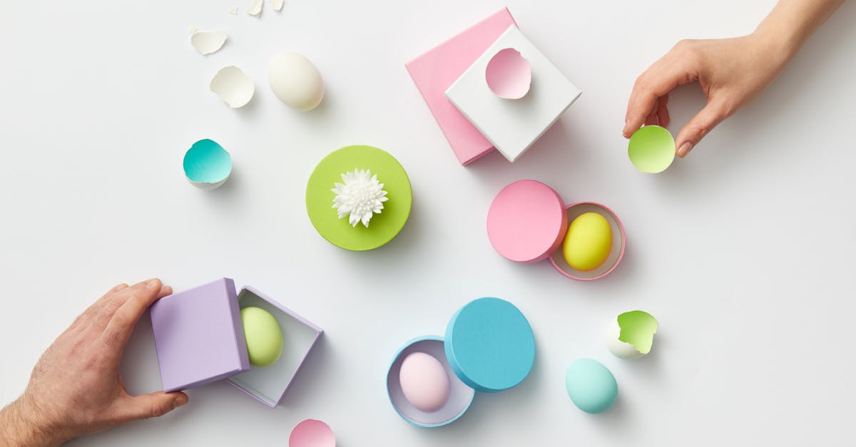 vibrant pastel eggs arranged in stylish boxes with hands creating an artistic flat lay