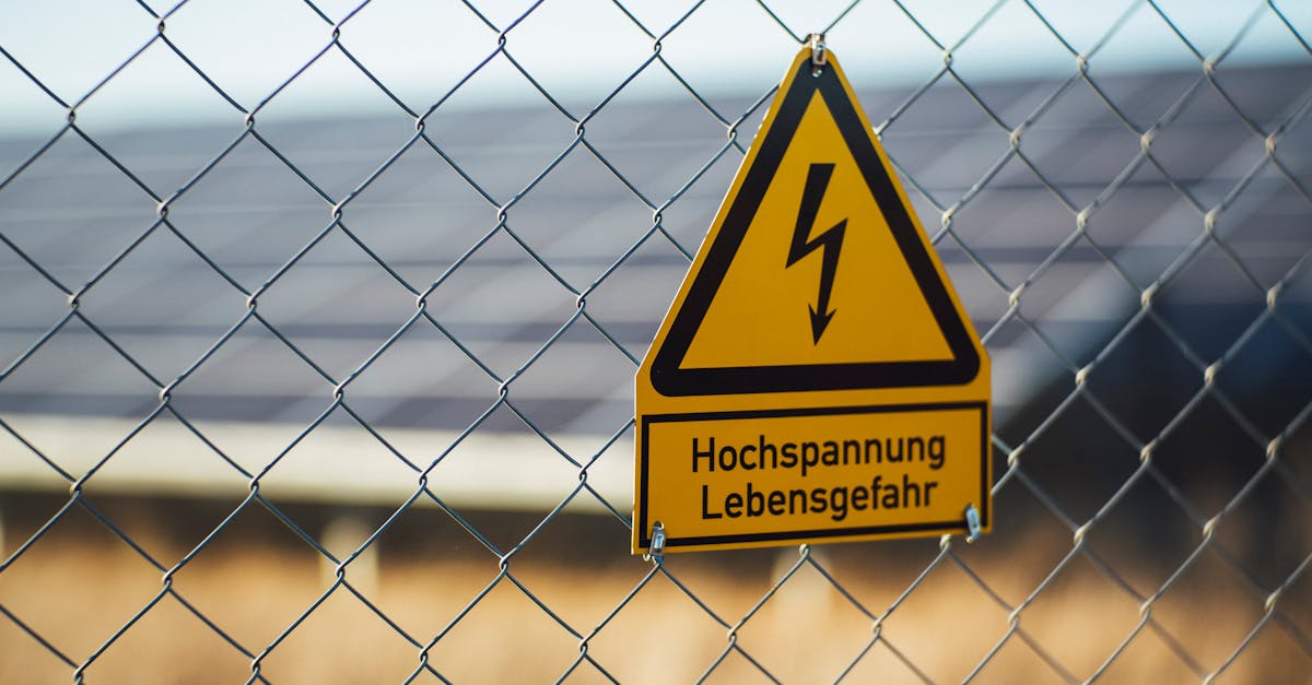 warning sign indicating high voltage danger on a chain link fence near solar panels